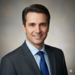 Профессиональный портрет русского бизнесмена, уверенный взгляд, дружелюбное выражение лица, студийное освещение.